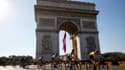 Le Slovène Tadej Pogacar (d) devant l'Arc de Triomphe lors de la 21e et dernière étape du Tour de France, entre Chatou et Paris, le 18 juillet 2021