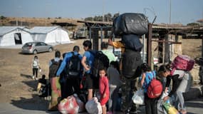 Des migrants attendent pour être dirigés vers  un nouveau campement de réfugiés après l'incendie du camp de Moria, sur l'ile de Lesbos, le 12 septembre 2020