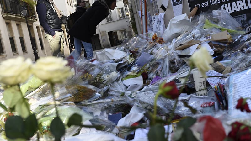 Des passants déposent des fleurs en hommage aux victimes des attentats contre Charlie Hebdo, le 7 janvier à Paris.