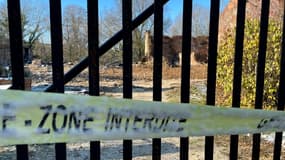 Un bandeau "Zone interdite" barre le portail de la propriété incendiée où deux corps ont été retrouvés, le 3 décembre 2023 à Châteauvilain en Isère