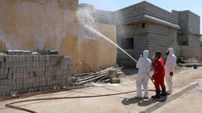 Des membres de la défense civile nettoient des quartiers de la ville de Taza, possiblement contaminée par une attaque chimique menée par Daesh. 