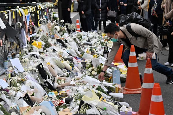 A man lays white flowers in memory of the victims of the deadly stampede during a Halloween celebration in Seoul on November 3, 2022.