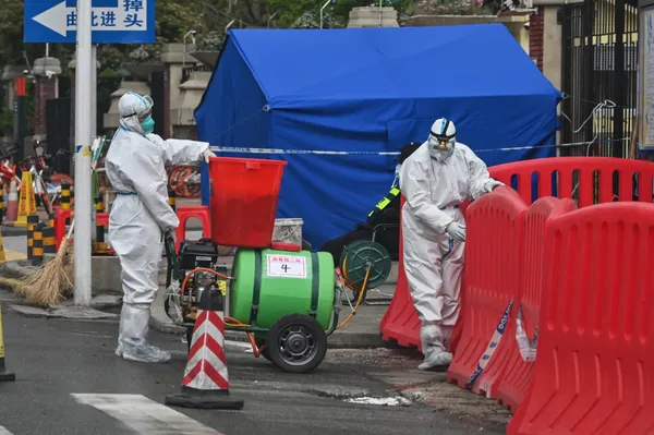 Des travailleurs portant un équipement de protection au marché de Huanan à Wuhan, en Chine, le 30 mars 2020, après le début de l'épidémie de Covid-19.