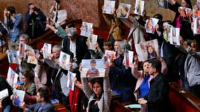 Des députés de gauche brandissent des portraits d'enfants qui, selon eux, ont été tués lors de l'offensive militaire israélienne à Gaza lors d'une séance de questions au gouvernement à l'Assemblée nationale, la chambre basse du Parlement français, à Paris, le 8 avril 2025.