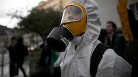 Un homme portant une protection complète lors d'une manifestation à Rouen accusant l'usine Lubrizol et les autorités de cacher des données