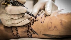 Une personne en tatoue une autre. (Illustration)