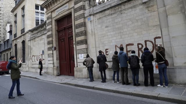 Les mains recouvertes de gants en latex, chacun des militants a dessiné une lettre en capitale sur le mur de pierre