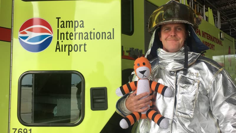 Le tigre en peluche Hobbes dans les bras d'un pompier de l'aéroport de Tampa en Floride.