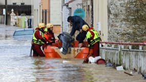 Des pompiers évacuent un habitant dans une rue inondée d'Isques, près de Boulogne-sur-Mer, le 7 novembre 2023 dans le Pas-de-Calais.