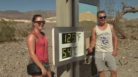 Des touristes posent devant un thermomètre indiquant 54 degrés aux Etats-Unis