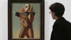 Une personne regarde la peinture "La Condottiere" (1925) du peintre italien Giorgio de Chirico