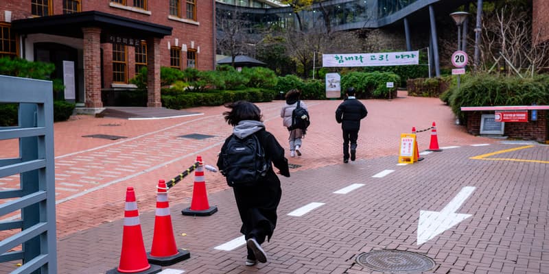 Des étudiants courent alors qu'ils arrivent pour passer l'examen annuel d'entrée à l'université au  lycée Ehwa à Séoul, le 16 novembre 2023. 