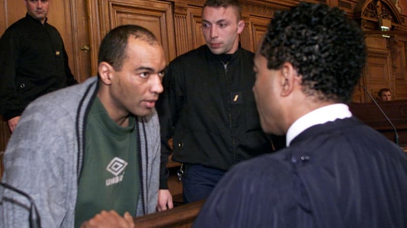 Guy Georges discute avec son avocat, le 19 mars 2001, lors de son procès.
