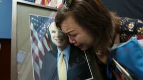 Citoyenne américaine d'origine vietnamienne devant le portrait de John McCain (illustration)