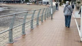 Une personne marchant sur la promenade Rose à Saint-Cyr-sur-Mer (Var) lors d'un épisode venteux le dimanche 9 mars 2025