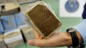 (image d'illustration) Un gendarme présente un paquet de résine de cannabis.