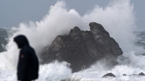 Un homme marche le long de l'océan à Porspoder (Finistère) le 27 décembre 2020, alors que la tempête Bella frappe les côtes françaises. 
