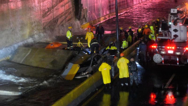 Des sauveteurs recherchent des personnes coincées sous un mur qui s'est effondré sur plusieurs véhicules après de fortes pluies à Saint-Domingue, le 18 novembre 2023.