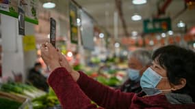 Une Chinoise utilise son smartphone pour payer ses achats à un marché de Chengdu, le 30 novembre 2020 en Chine