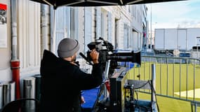 Un homme règle sa caméra pendant le tournage du film THE NEW WORKERS LEAVING THE FACTORY", à l'occasion du 130e anniversaire de la naissance du cinéma, à l'Institut Lumière de Lyon, en France, le 19 mars 2025.