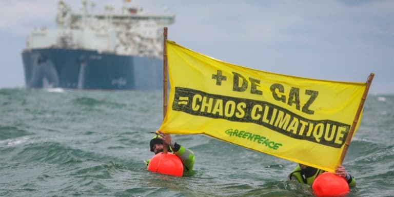 Des militants de Greenpeace France déploient une banderole près du méthanier de TotalEnergies Cape Ann qui s'apprête à entrer dans le port du Havre, le 18 septembre 2023
