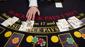 Un croupier distribue les cartes à une table de black jack (image d'illustration)