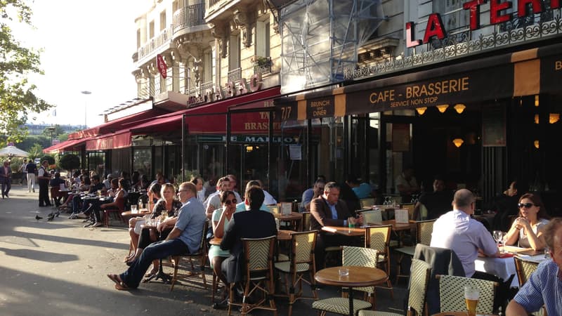 Des personnes attablées en terrasse sous le soleil à Paris (Photo d'illustration)