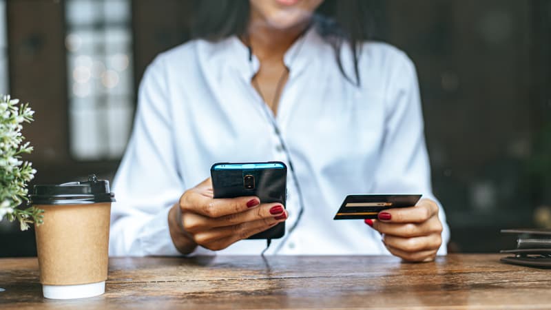 Une femme effectuant un paiement avec sa carte bancaire depuis son téléphone.