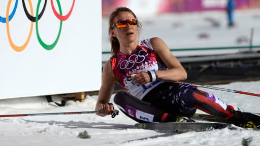 La sportive américaine Sophie Caldwell se repose sur la neige à la fin d'un cross-country de 10.000 mètres, le 13 février 2014.