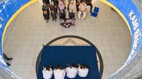 Des hommes font une prière avant d'être fouettés par des membres de la police de la charia pour avoir participé à des jeux d'argent en ligne à Banda Aceh, le 30 janvier 2025.