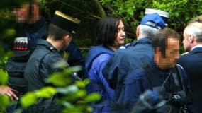 Monique Olivier (c), l'épouse de Michel Fourniret, escortée par des policiers du GIGN, assiste aux premières fouilles au château de Sautou, le 3 Juillet 2004 à Donchéry