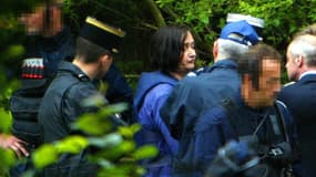 Monique Olivier (c), l'épouse de Michel Fourniret, escortée par des policiers du GIGN, assiste aux premières fouilles au château de Sautou, le 3 Juillet 2004 à Donchéry