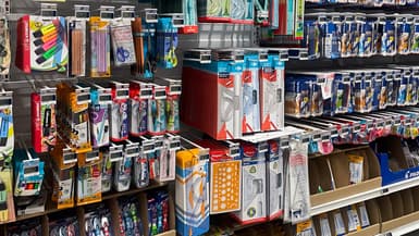 De nombreux stylos, règles, équerres, compas, ciseaux et autres fournitures scolaires sont exposés sur un présentoir dans un supermarché avant la rentrée scolaire à Lyon, en France, le 15 août 2025. 