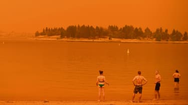 Des personnes en Australie sous un ciel rouge causé par les incendies ce samedi 4 janvier