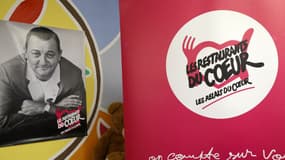 Le logo des Restos du coeur et une affiche du fondateur de l'association, Coluche, le 21 novembre 2023 à Asnières-sur-Seine 