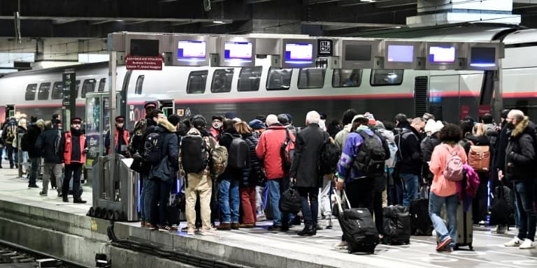 Des voyageurs patientent sur un quai de la gare Montparnasse avant d'embarquer dans un train lors d'une grève des contrôleurs de la SNCF, à Paris le 2 décembre 2022