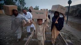 A Nowshera, dans le nord-ouest du Pakistan, des habitants regagnent leur domicile avec des vivres distribués par l'armée. Selon l'Unicef, plus de trois millions de personnes ont été touchées par les importantes inondations survenues dans le nord-ouest du