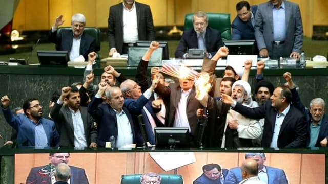 Photo distribuée par le Parlement iranien montrant des députés en train de brûler un drapeau américain en papier, le 9 mai 2018 à Téhéran