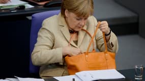 Angela Merkel avec un modèle orangé du sac Le Foulonné de Longchamp.