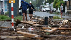 Des piétons au milieu des débris à Saint-Paul de la Réunion après le passage du cyclone Garance le 28 février 2025