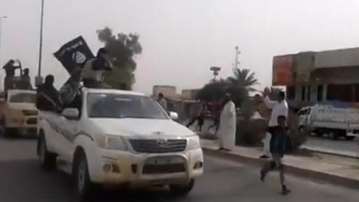 Image tirée d'une vidéo visible sur Youtube visible le 17 juin 2014, montrant des hommes armés tenant un drapeau de l'EI dans la ville de Baïji en Irak