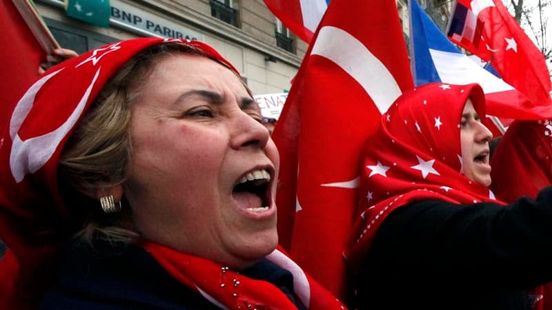 Manifestantes franco-turques lors d'un rassemblement devant le Sénat, à Paris, pour protester contre l'adoption d'une loi pénalisant la négation des génocides, notamment celui des Arméniens en 1915 par les Turcs. Le Parlement français a adopté définitivem