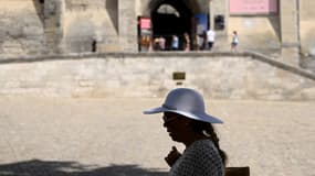 Une femme fait une pause à l'ombre d'un arbre à Avignon, dans le sud de la France, le 17 juillet 2023.