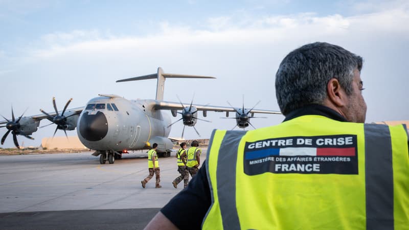 Un membre du personnel des Affaires étrangères françaises se tenant sur la base aérienne militaire française de Djibouti pendant l'évacuation d'environ 100 personnes du Soudan sur le premier vol français quittant le pays en guerre, le 23 avril 2023.