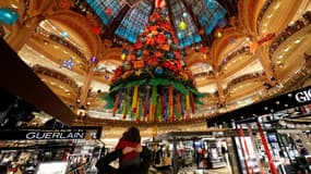 Un client et son enfant passent devant l'arbre de Noël du magasin des Galeries Lafayette à Paris, qui a rouvert samedi après un allègement du confinement en France, le 28 novembre 2020