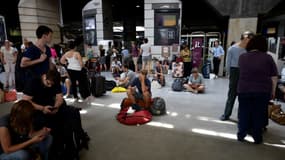 Des usagers de la SNCF attendent leur train à la gare Montparnasse, le 27 juillet 2018 à Paris. 