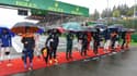 Des pilotes attendent sous la pluie sur la ligne de départ du GP de F1 de Belgique menacé par le mauvais temps, le 29 août 2021 à Spa-Francorchamps 