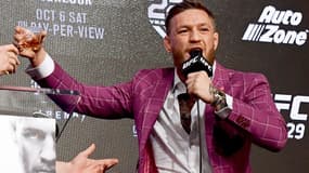 Conor McGregor voit un verre de Proper Twelve en conférence de presse avant son combat face à Khabib Nurmagomedov en octobre 2018