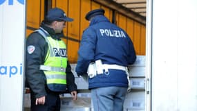 Deux policiers vérifient un camion à la recherche d'éventuels clandestins entre la France et l'Italie (image d'illustration)