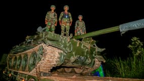 Cette photo prise le 26 octobre 2025 et diffusée par l'Agence Kampuchea Press montre des soldats cambodgiens debout sur un char chargé sur un camion dans une rue de la province de Preah Vihear